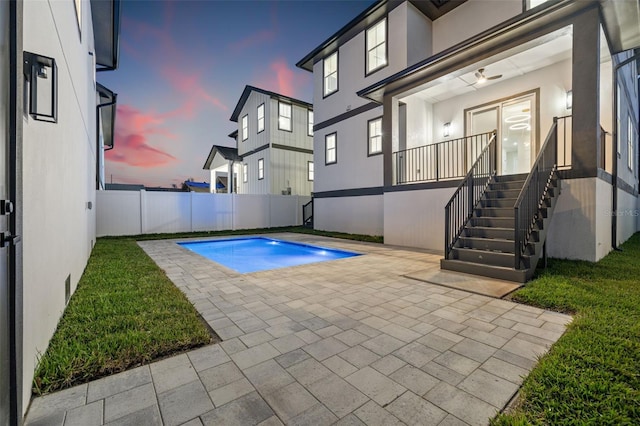 pool at dusk with a patio area