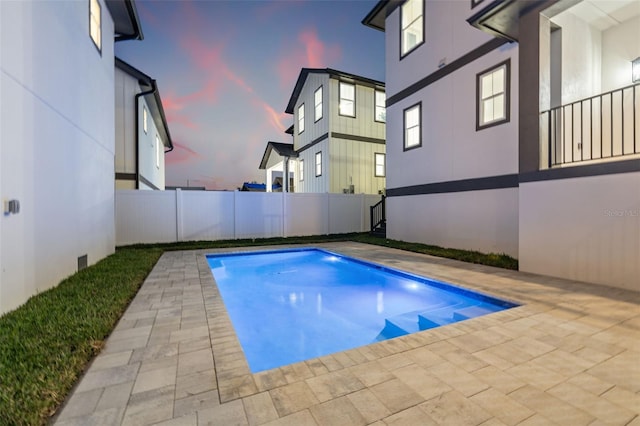 pool at dusk featuring a patio