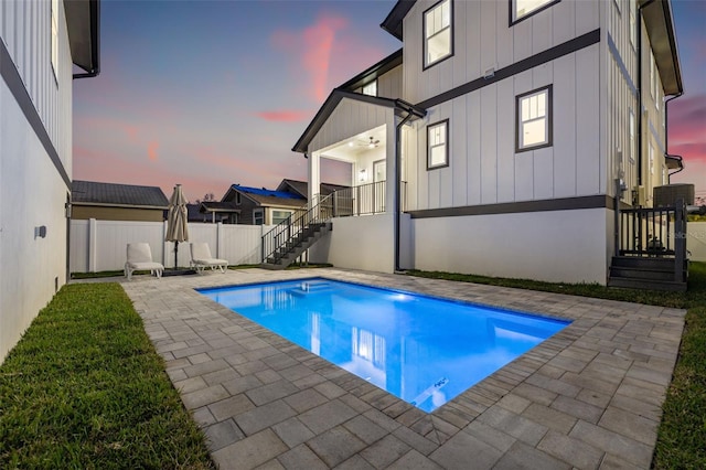 pool at dusk featuring a patio