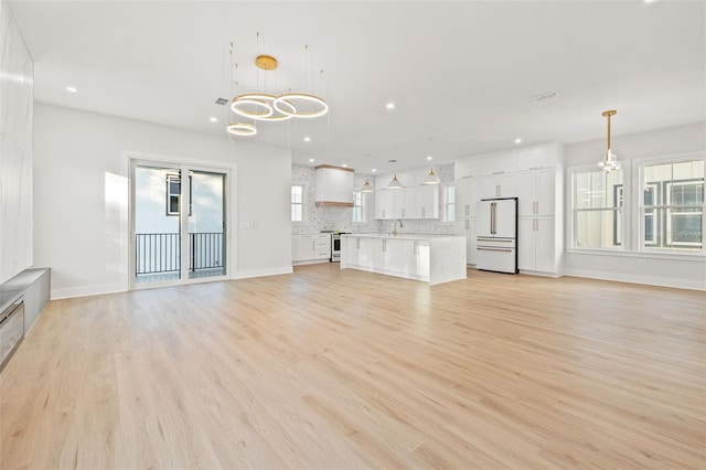 unfurnished living room featuring light hardwood / wood-style floors and sink