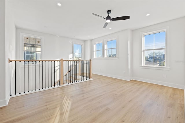 empty room with ceiling fan and light hardwood / wood-style floors