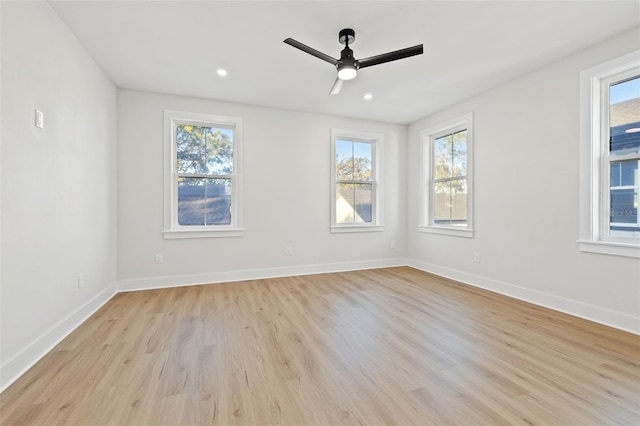 spare room with ceiling fan, light wood-type flooring, and a wealth of natural light