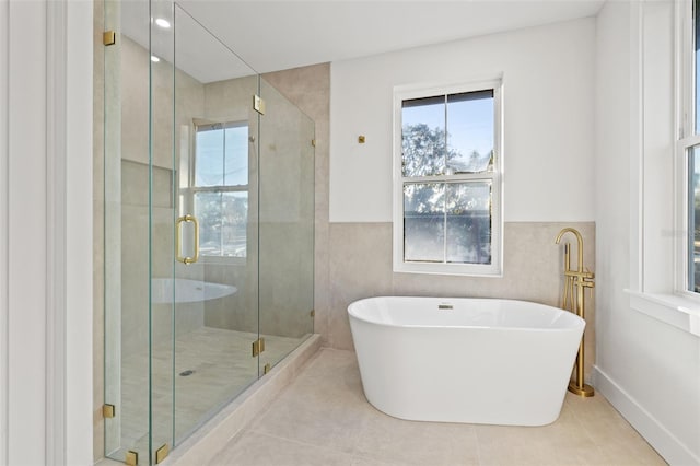 bathroom with tile patterned flooring, shower with separate bathtub, and tile walls