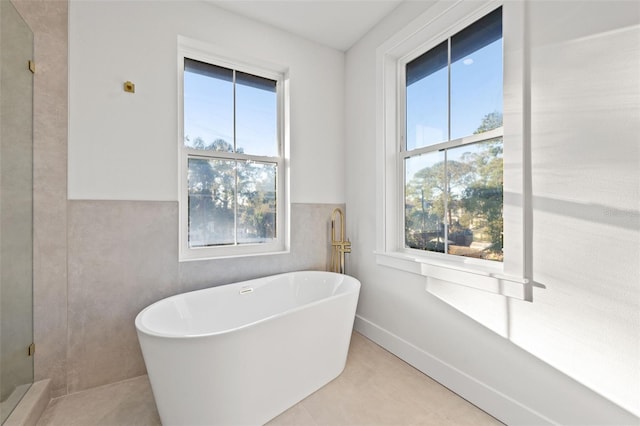 bathroom with tile patterned floors and a tub