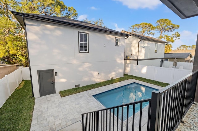 back of property featuring a patio area and a fenced in pool