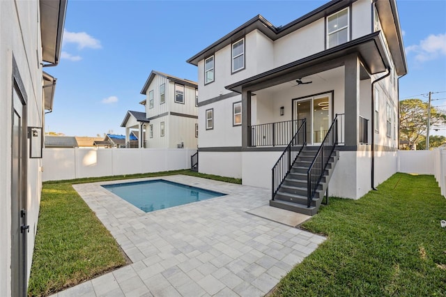 view of pool with a lawn, ceiling fan, and a patio