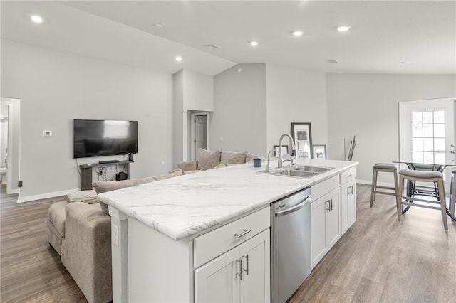 kitchen featuring white cabinetry, lofted ceiling, sink, and stainless steel dishwasher