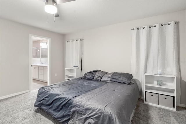 bedroom featuring ceiling fan, connected bathroom, sink, and carpet