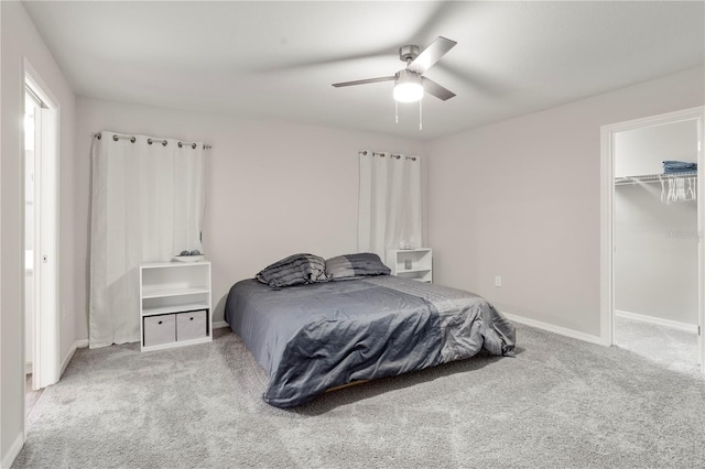 bedroom featuring a closet, carpet floors, ceiling fan, and a spacious closet