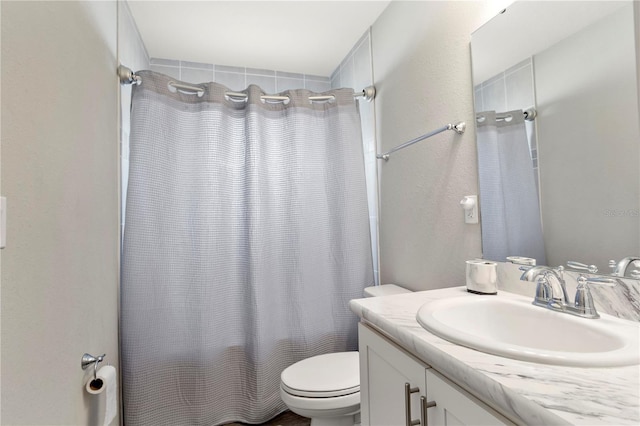 full bathroom with vanity, shower / tub combo, and toilet