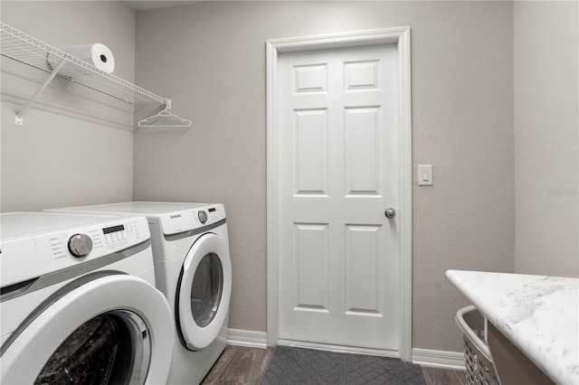 clothes washing area with dark wood-type flooring and washer and dryer