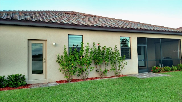 rear view of property with a yard and a sunroom