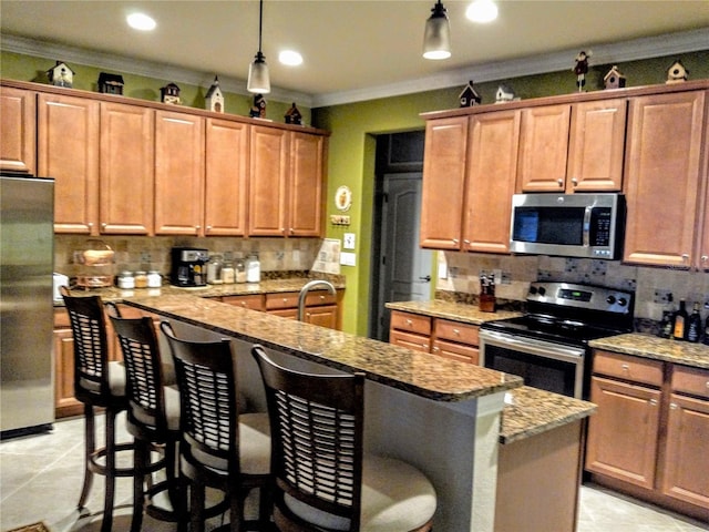 kitchen with a breakfast bar area, tasteful backsplash, stainless steel appliances, pendant lighting, and light tile patterned floors