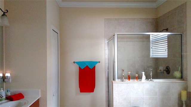 bathroom featuring a shower with shower door, vanity, and crown molding