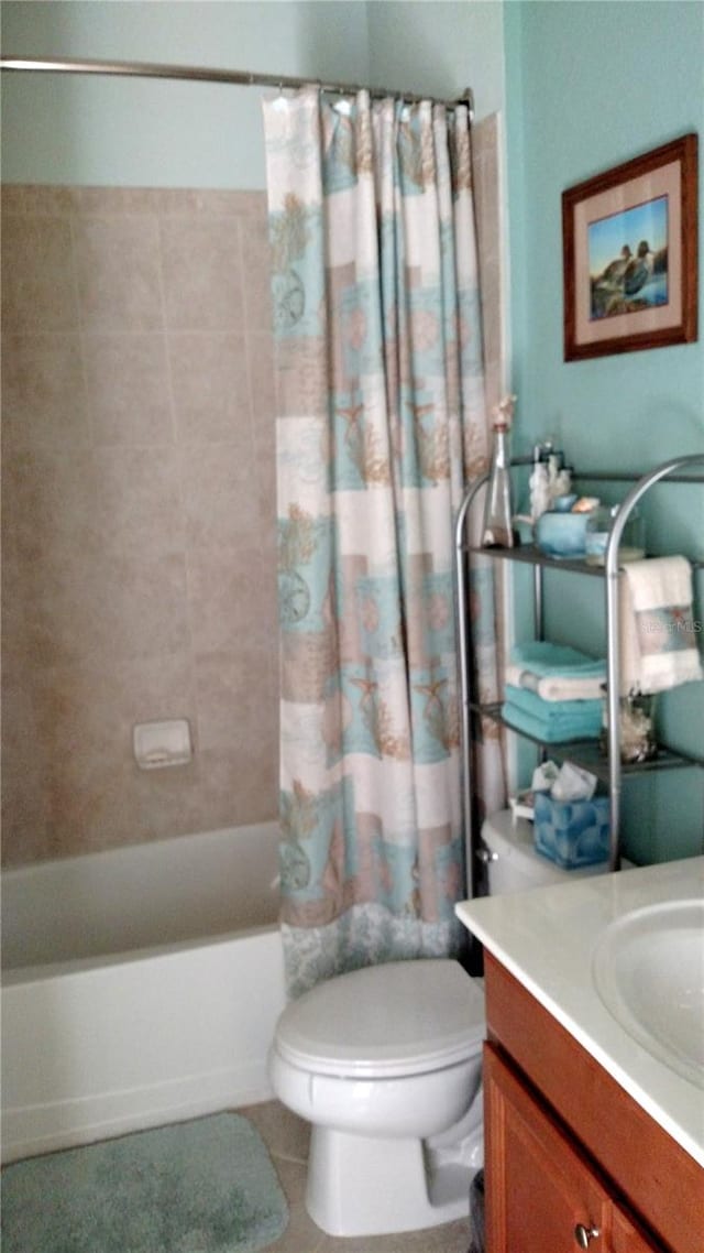 full bathroom with shower / tub combo with curtain, vanity, tile patterned flooring, and toilet