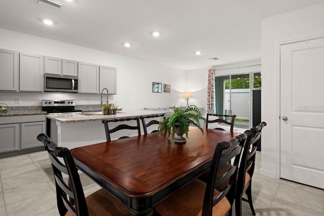 dining space with sink and light tile patterned floors