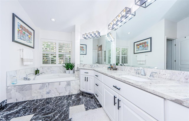 bathroom with vanity and shower with separate bathtub