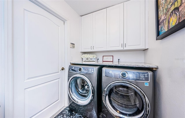 laundry area featuring washing machine and dryer and cabinets