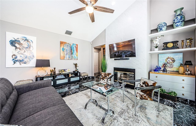 living room with ceiling fan, a large fireplace, and vaulted ceiling