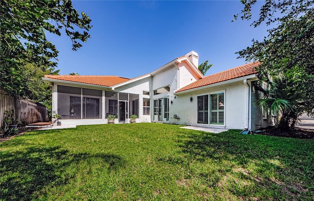 back of house featuring a lawn and a sunroom