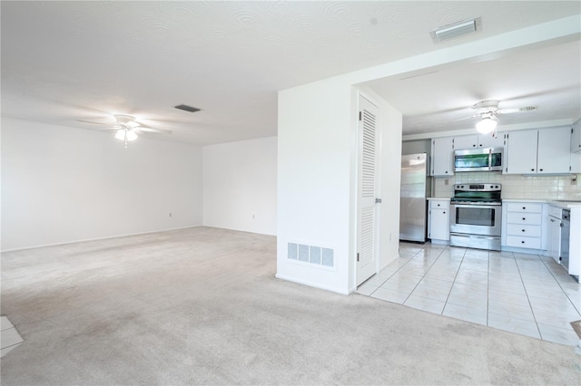 kitchen with light carpet, appliances with stainless steel finishes, and tasteful backsplash