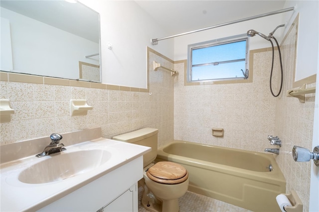 full bathroom featuring tiled shower / bath combo, tile patterned floors, toilet, vanity, and tile walls