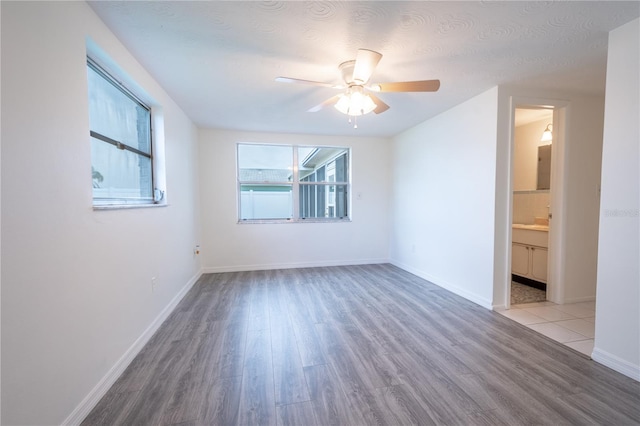 empty room featuring ceiling fan, light hardwood / wood-style flooring, and a textured ceiling