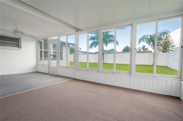 unfurnished sunroom with beam ceiling, a wealth of natural light, and ceiling fan