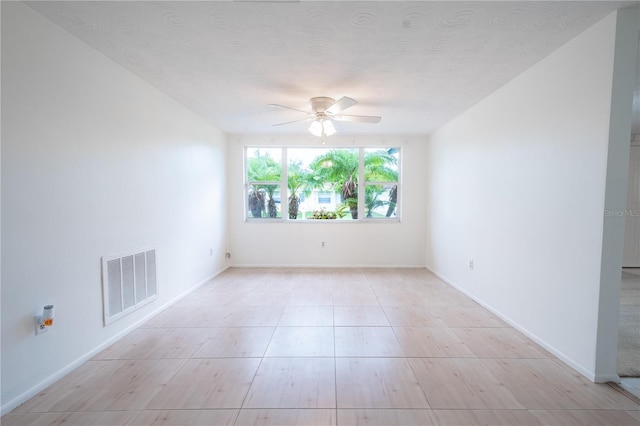 unfurnished room with ceiling fan and a textured ceiling