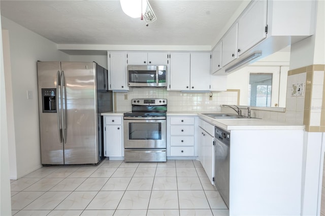 kitchen with tasteful backsplash, white cabinetry, sink, and appliances with stainless steel finishes