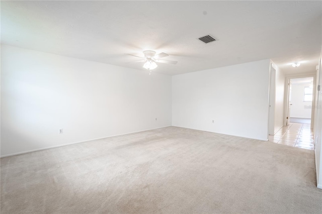 carpeted spare room with ceiling fan