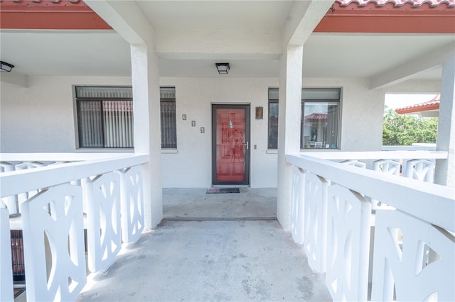 doorway to property featuring a tiled roof and stucco siding