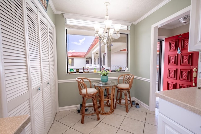 dining area with baseboards, ornamental molding, a chandelier, and light tile patterned flooring