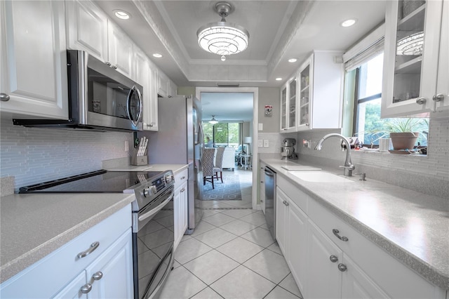 kitchen with glass insert cabinets, white cabinets, and stainless steel appliances