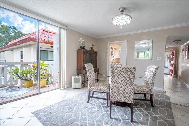 dining room featuring ornamental molding, a healthy amount of sunlight, baseboards, and light tile patterned floors