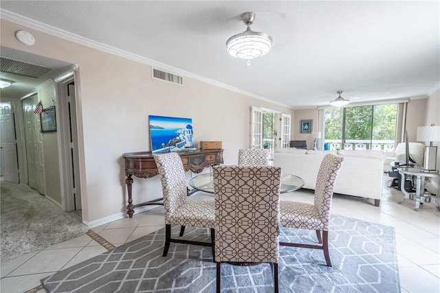 dining space with baseboards, visible vents, crown molding, and light tile patterned flooring