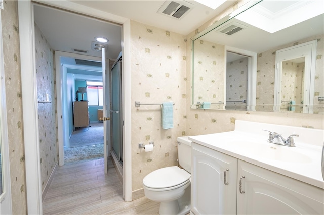 bathroom featuring toilet, wallpapered walls, visible vents, and vanity