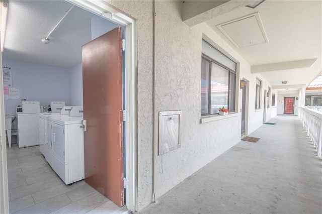 corridor featuring attic access and separate washer and dryer