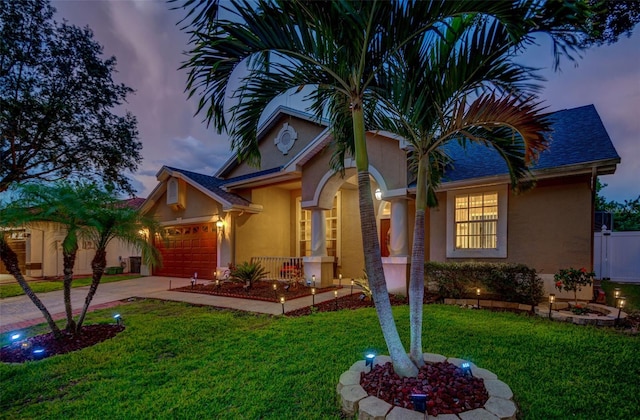 view of front facade with a garage and a yard