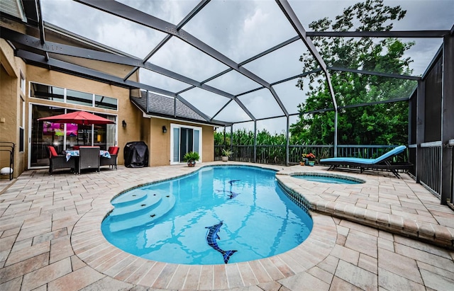 view of swimming pool with glass enclosure, a patio area, an in ground hot tub, and grilling area