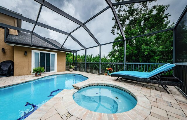 view of pool with a lanai, a patio area, area for grilling, and an in ground hot tub