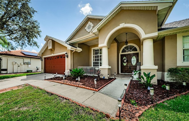 view of front facade featuring a garage, solar panels, and a porch