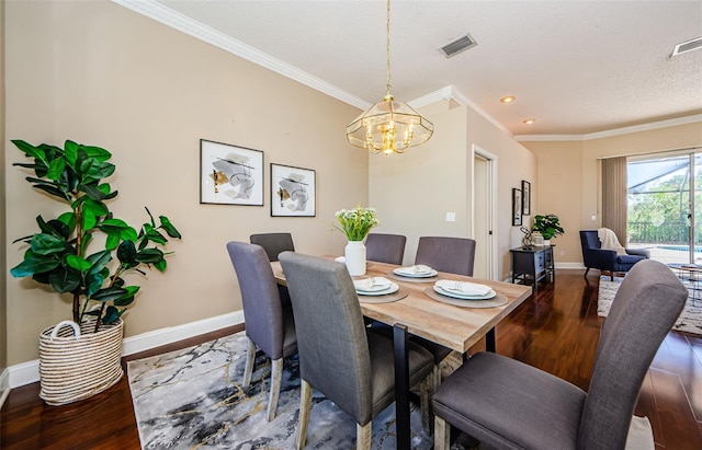 dining space with a textured ceiling, ornamental molding, hardwood / wood-style flooring, and a notable chandelier