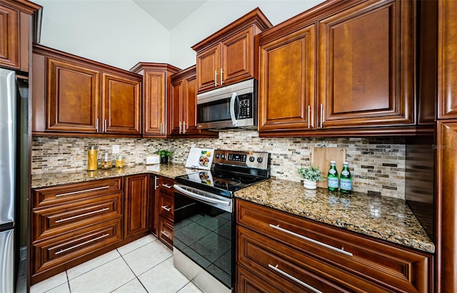 kitchen featuring light stone counters, light tile patterned flooring, appliances with stainless steel finishes, and tasteful backsplash