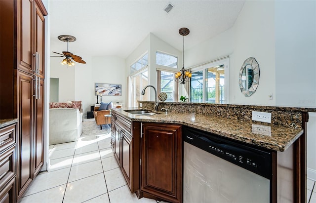 kitchen with light tile patterned floors, stainless steel dishwasher, dark stone countertops, ceiling fan with notable chandelier, and sink