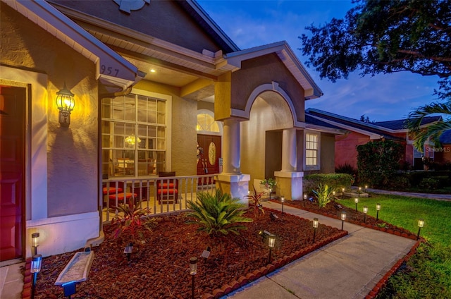 exterior entry at dusk featuring a porch