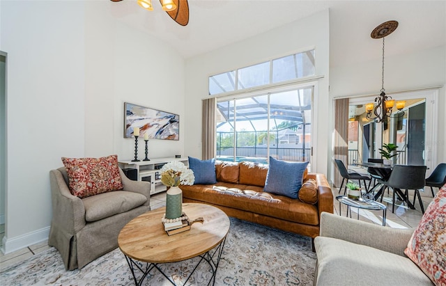 tiled living room featuring ceiling fan with notable chandelier