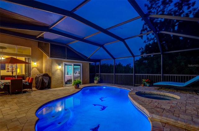 pool at night with a lanai, an outdoor hangout area, a patio, and an in ground hot tub