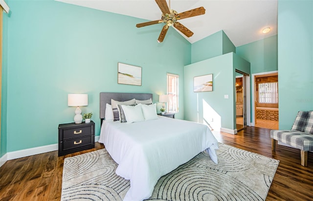 bedroom featuring ceiling fan, connected bathroom, dark hardwood / wood-style floors, and high vaulted ceiling