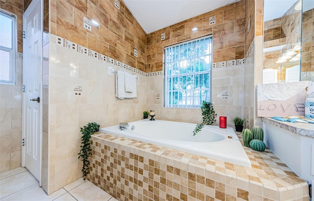 bathroom with tiled bath, a textured ceiling, tile patterned flooring, and tile walls